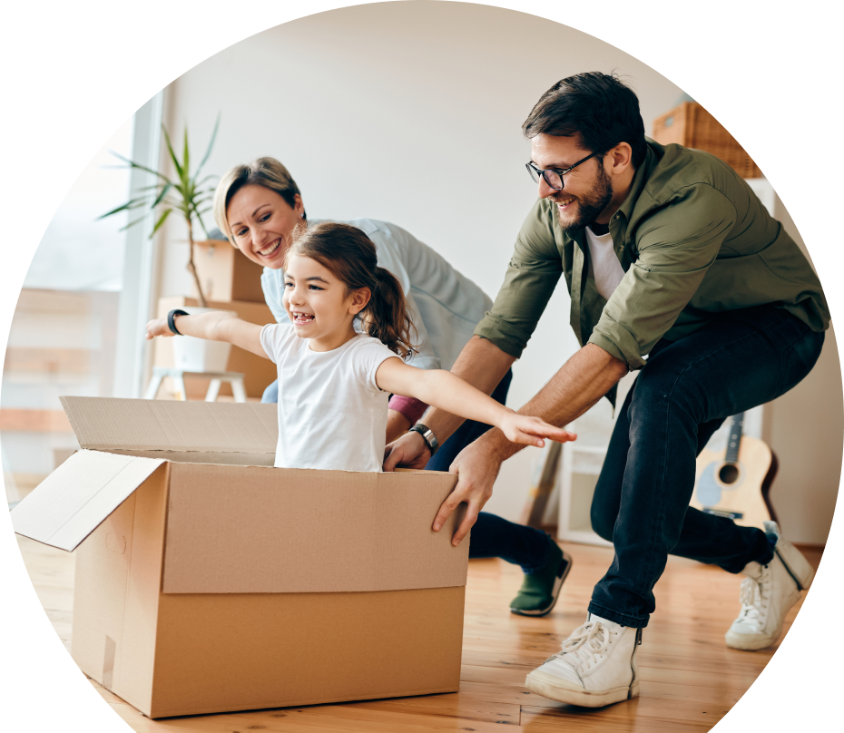 home-insurance-graphic Parents playing with kid, pushing her on the floor in a cardboard box.